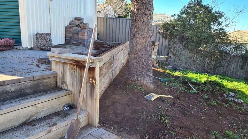Timber retaining wall under construction in a backyard