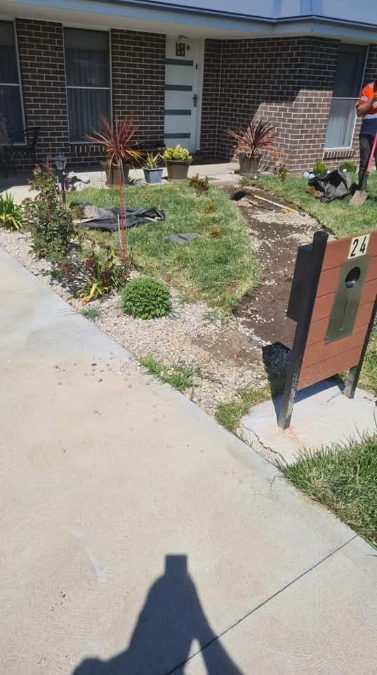 Crew member edging a residential front garden bed