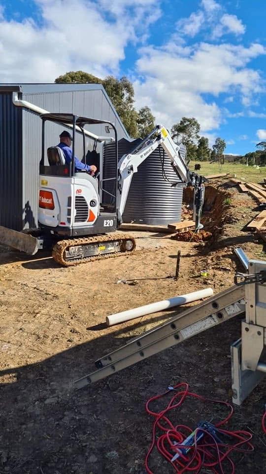 Bobcat excavator trenching for a new rural water tank installation